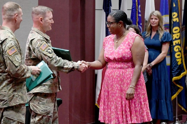 Wanda Gilbert receives a 15- year service award from Garrison Commander Col. Brian Cozine.