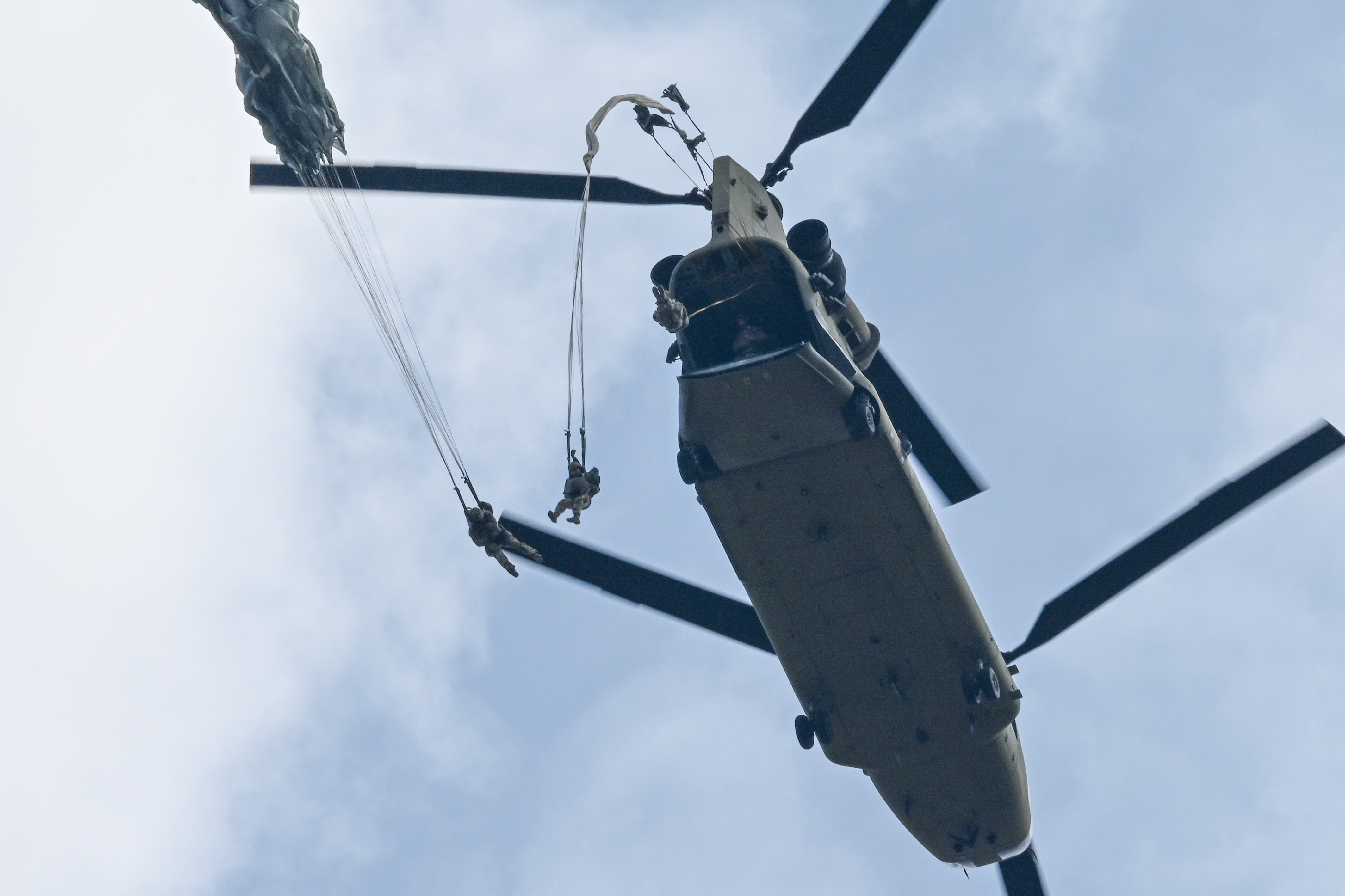 U.S. Army paratroopers assigned to 1st Squadron, 91st Cavalry Regiment, 173rd Airborne Brigade jump out of a CH-47 Chinook helicopter at Bunker Drop Zone, Grafenwoehr, Germany, June 28, 2024. 1-91 CAV, 173rd AB conducts a family jump in order to...