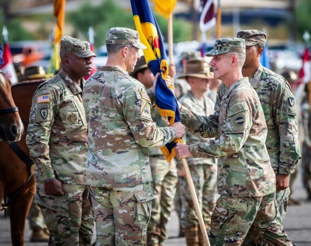 Lt. Gen. Stephen G. Smith, the Deputy Commanding General of U.S. Army Forces Command, passes the U.S. Army National Training Center and Fort Irwin guidon to Brig. Gen. Brandon C. Anderson, bestowing the honor of command upon during the 24th leader...