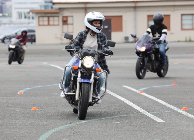 Army spouse Grace Fernandez and other riders practice an exercise during the Basic Rider Course 1 at Yokohama North Dock, Japan, July 19, 2024. U.S. Army Garrison Japan recently restarted its motorcycle safety courses after a yearslong hiatus to...