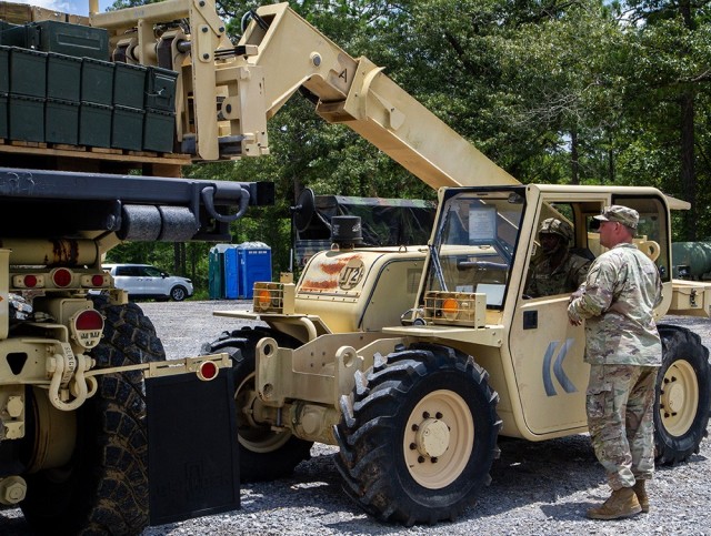 Army Sgt. Semaj Lawry (driving forklift), motor transport operator, and Army Sgt. Philip Seymour (right), ammo specialist, unload a pallet of ammunition they have just transported from an ammunition supply point to an ammunition holding area at...