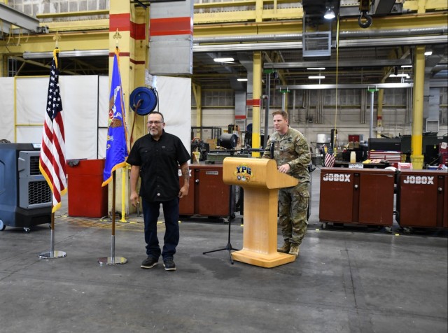 Rick Ramirez (left), team lead for wheeled vehicles in Yuma Test Center&#39;s Maintenance Branch, is praised by Yuma Test Center Commander Lt. Col. Kevin Hicks (right) in a ceremony honoring his assistance to a Yuma Police Department officer...