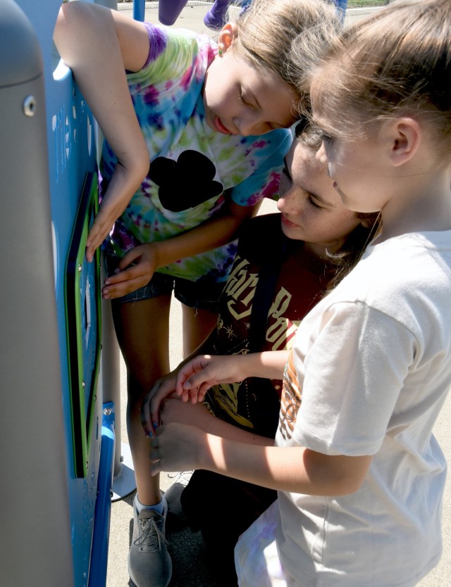 Madison Maxwell, 10, daughter of 1st Sgt. John Maxwell, 502nd Engineer Battalion, Molly Griggs, 10, daughter of Maj. Charles Griggs, 1st Army Division, and Jade Smith, 10, daughter of Sgt. 1st. Class Kyle Smith, Recruiting and Retention College instructor, play an interactive game at the new inclusive playground on Fort Knox, Kentucky, July 18, 2024.