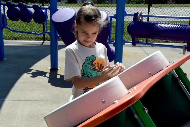 Jade Smith, 10, daughter of Sgt. 1st. Class Kyle Smith, Recruiting and Retention College instructor, plays on an interactive game at the new inclusive playground on Fort Knox, Kentucky, July 18, 2024.