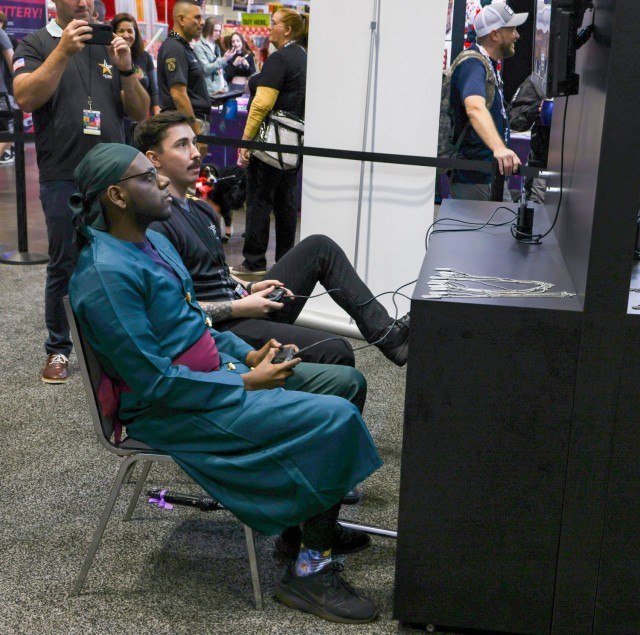 ORLANDO, Fla. – Staff Sgt. Hunter Sanborn (center left), a fire support specialist currently assigned to U.S. Army Esports, Recruiting Outreach Company, U.S. Army Accessions Mission Support Battalion competes against guests of MegaCon Orlando Feb. 01, 2024 at the Orange County Convention Center. Sanborn and his unit met with thousands of visitors to compete and to share their career experiences in the U.S. Army.