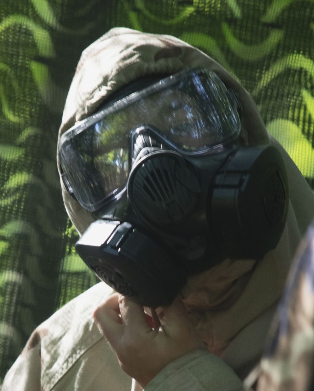 Cadet Rebecca Karis secures her M50 protective mask as she dons her Mission Oriented Protective Posture gear during chemical, biological, radiological, nuclear training at Cadet Summer Training Advanced Camp on Fort Knox in Kentucky, July 19, 2024 (U.S. Army photo by Shannon Collins).