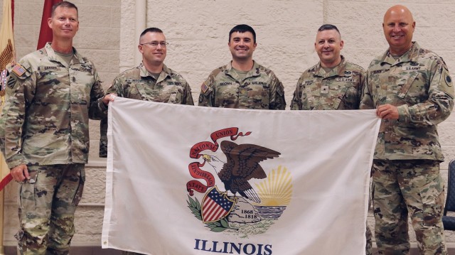 Brig. Gen. Justin Osberg presented the Soldiers of Logistics Advisor Team 6620 with an Illinois State Flag to carry on the team&#39;s deployment to Africa. Pictured from left on Aug. 4, 2024, is State Command Sgt. Maj. Phillip Barber, Logistics Advisor Chief Warrant Officer 2 Christopher Fitch, Team Leader Maj. Walter Brown, Osberg, and State Command Chief Warrant Officer Chief Warrant Officer 5 Tom Black.