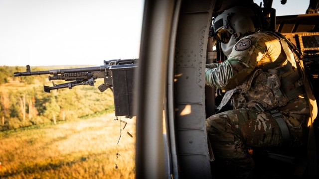 U.S. Army Spc. Austin Banks fires the M240 machine gun during mounted gunnery in a UH-60 Black Hawk at Camp Grayling Army Airfield in Grayling, Michigan, July 16, 2024. Banks, a crew chief in Bravo Company 2/147th Assault Helicopter Battalion,...