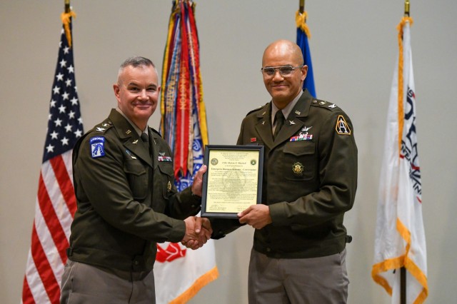 PEO EIS Deputy Program Executive Officer Col.(P) RJ Mikesh (l.) presents the EBS-C charter to Project Manager Col. Melvin Mitchell (r.) at an assumption of charter ceremony, July 23, 2024.