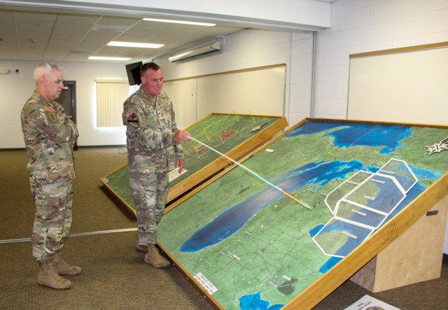 Col. Scott Meyers, commander of Camp Grayling Joint Maneuver Center, shows SFAC Commander Brig. Gen. Kevin Lambert a map of Camp Grayling during an overview brief.