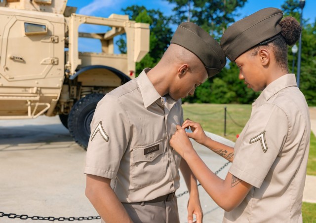 Pvt. Michanti Jackson adjusts Pvt. Darrin Jackson’s uniform following their Infantry One Station Unit Training graduation, Aug. 9, 2024, on Inouye Field at the National Infantry Museum in Columbus, Georgia.