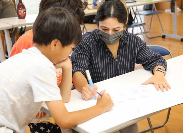 Priscilla Homan (right), a victim advocate for the 38th Air Defense Artillery Brigade's Sexual Harassment and Assault Response and Prevention Unit, plays tic-tac-toe with residents of the Sagamihara Minami Children's Home during an exchange event in Sagamihara.