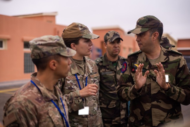 U.S. Air Force Lt. Col. Rodrigo Ocampo and Capt. Cassaundra Preston, both part of the U.S. Air Force Language-Enabled Airmen Program, speak with a soldier from the Royal Moroccan Armed Forces on Aug. 15, 2024, at Agadir, Morocco. Ocampo and...