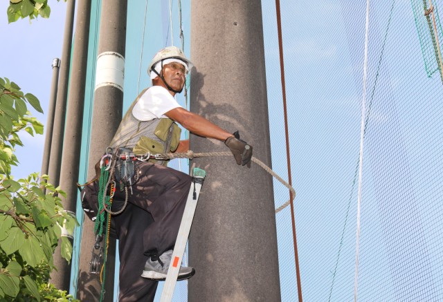 A contractor prepares to repair a net on the driving range at Camp Zama Golf Course in Japan on August 19, 2024. The course is currently undergoing extensive repairs to the mesh netting as part of an ongoing effort to keep balls within the course perimeter.