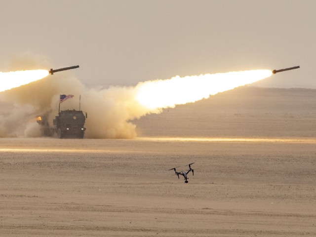 A bandeira americana no topo de um High Mobility Artillery Rocket Systems se curva enquanto o HIMARS dispara durante uma missão de fogo combinado durante o exercício Al Tahreer. O HIMARs, parte da Task Force Spartan, fazia parte de uma missão de fogo combinado com o Kuwait Land...