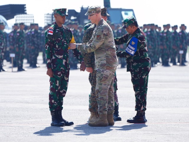 Mayor Jenderal Joseph R. Harris II, Kepala Staf dan Komandan Garda Nasional Udara Hawaii, tengah, dan Marsekal Udara Vidyarko Ikoputra, kanan tengah, wakil komandan Kodiklat, mengenakan ban lengan resmi di Tendara National Indonesia...