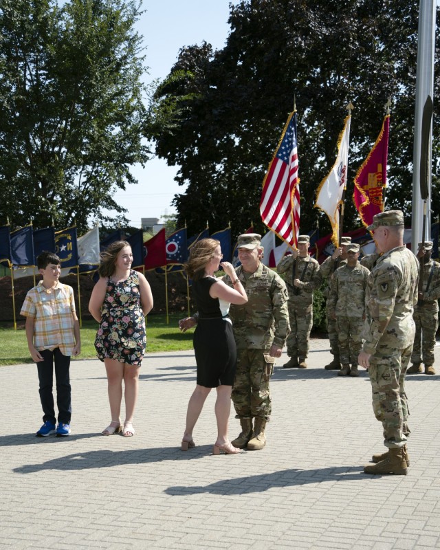 Michelle Lalor, wife of Brig. Gen. Michael B. Lalor, U.S. Army Tank-automotive and Armaments Command (TACOM) commanding general, places a two-star insignia on her husband’s uniform during his promotion from brigadier general to major general. ...