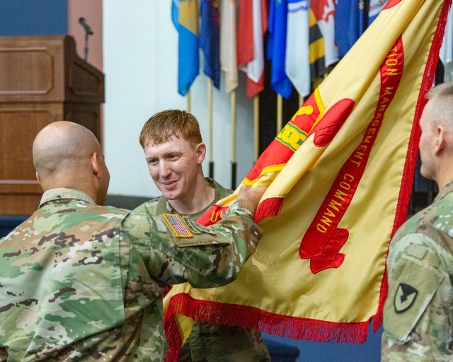 Col. David Stewart, Commander, U.S. Army Garrison- Fort Belvoir, left, passes the colors to incoming Command Sgt. Maj. Daniel Hopkins during a Change of Responsibility Ceremony in Fort Belvoir's Thurman Auditorium, Sept. 12, as outgoing...