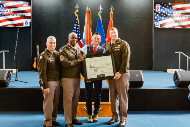 The U.S. Army Aviation Center of Excellence command team presents an award to SSG (R) Keni Thomas, 3rd Ranger Battalion combat veteran, who fought in the Battle of Mogadishu, at the 31st anniversary of the Battle of Mogadishu inside the Army...