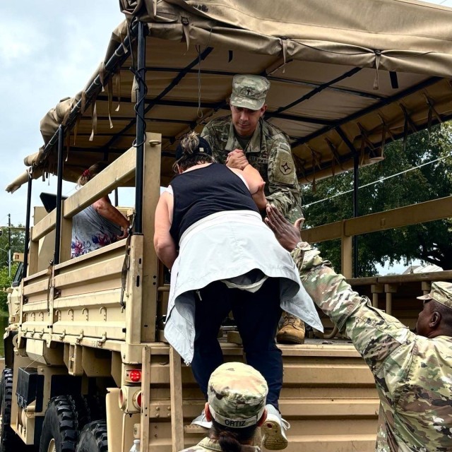 Florida National Guard Soldiers evacuate citizens from flooded areas in a high-water vehicle.