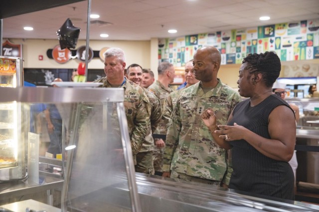 Chontrelle Sturdivant, Food Program Management Office manager, guides Lt. Gen. Kevin D. Admiral, III Armored Corps and Fort Cavazos commander, and Command Sgt. Maj. John P. McDwyer, III Armored Corps and Fort Cavazos command sergeant major, through the new Headquarters Department of the Army Go for Green Action Station Oct. 9, 2024, at the Operation Iraqi Freedom Dining Facility at Fort Cavazos. 