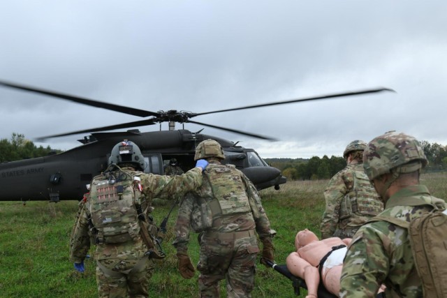 U.S. Army Sgt. Preston Clark, a flight medic with 12th Combat Aviation Brigade, accompanies Soldiers with the Headquarters and Headquarters Company, 56th Stryker Brigade Combat Team, Pennsylvania National Guard, as they transported a simulated wounded Soldier to an HH-60 Black Hawk helicopter during an air medevac exercise. (U.S. Army National Guard photo by Capt. Leanne Demboski)