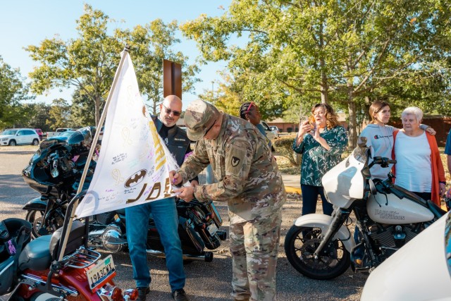 Col. John P. Miller III, Fort Novosel garrison commander, signs the childhood cancer awareness flag during the 7th annual post-wide motorcycle ride for cancer Oct. 18 on Fort Novosel.