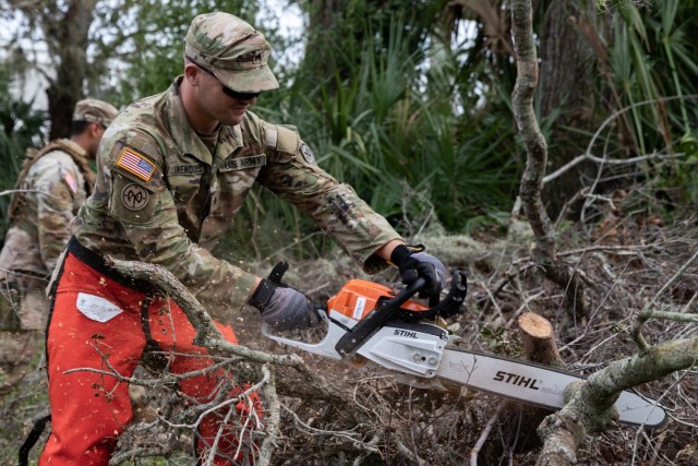 New York Army National Guard Sgt. Tyler Linendoll, an infantryman assigned to Charlie Company, 2nd Battalion, 108th Infantry Regiment, 27th Infantry Brigade Combat Team, cuts downed tree branches with a chainsaw following Hurricane Milton in Palmetto, Florida, Oct. 11, 2024. Soldiers from the 27th IBCT worked with members of the Florida Army National Guard to provide relief to communities impacted by the hurricane. (U.S. Army National Guard photo by Spc. Joseph Liggio)