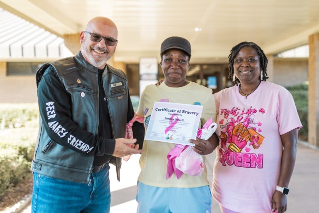 Sam Baker and Monteka Freeman present a certificate of bravery to Dorthy Newell at Silver Wings Golf Course during the 7th annual post-wide motorcycle ride for cancer Oct. 18 on Fort Novosel.