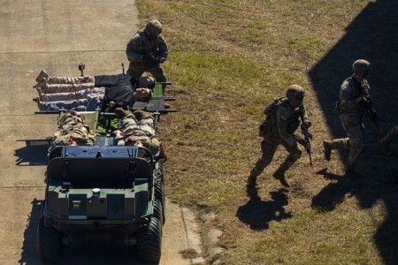 Soldiers of the Maneuver Center of Excellence Experimental Company, 1st Battalion, 29 Infantry Regiment, 316th Cavalry Brigade, employ integrated robotics during a simulated operation as attendees of the Human Machine Integration Summit II view...