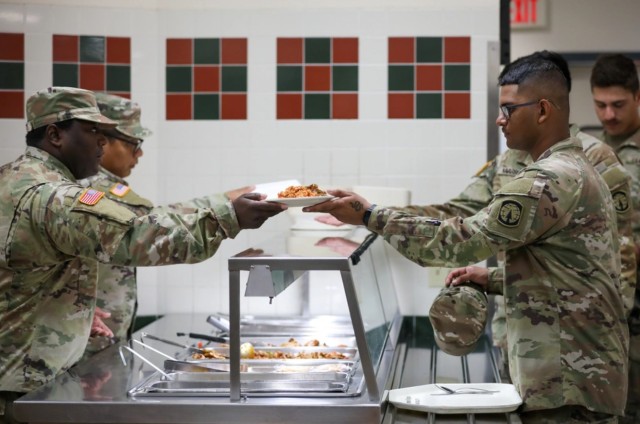 Spc. Vasco Watts serves lunch to Soldiers at the Muleskinner Warrior Restaurant, Fort Drum, New York. Easy food access can enhance military service members’ overall quality of life.