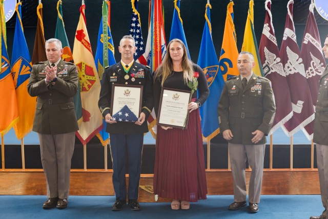 Chief Warrant Officer Four Marc Johnson stands with his spouse at the Fort Novosel quarterly retirement ceremony inside the Army Aviation Museum Oct. 25.