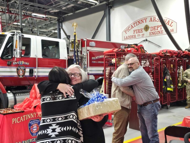 PICATINNY ARSENAL, N.J. - Christopher Foster (right) hugs Robert Frutchey, Chief of Police at Aberdeen Providing Ground, Maryland, and former Picatinny Arsenal Police Chief, as their wives also embrace during Foster’s retirement ceremony at the Picatinny Arsenal fire station on Oct. 17. 