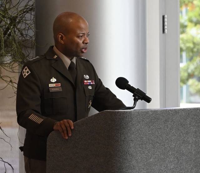 A man standing behind a podium with a microphone attached on top speaks. 