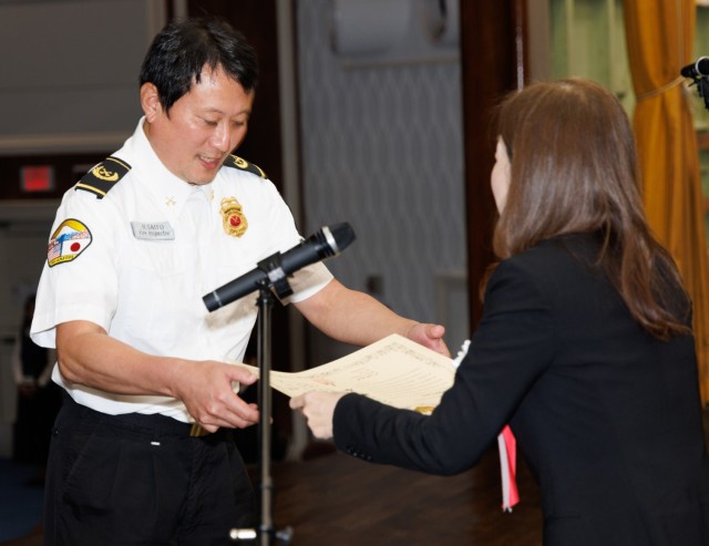 Hiroyuki Saito, left, a fire inspector at the Directorate of Emergency Services, receives a certificate from Rie Suetomi, director of the South Kanto Defense Bureau, during a length-of-service ceremony at Camp Zama, Japan, Oct. 29, 2024. The ceremony recognized 250 local employees for their nearly 6,000 years of combined service to U.S. Forces Japan.