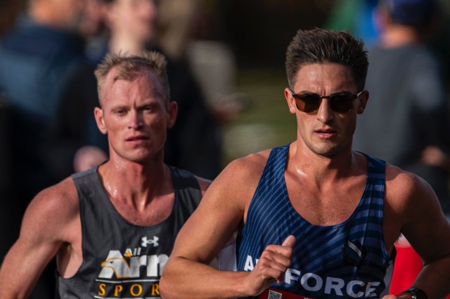 Army Capt. Kyle Smith, from Linden, Michigan, and Air Force Capt. George Henry Crist, from Sacramento, California, pace in a pack at mile marker 16 during the 2024 Marine Corps Marathon, held in conjunction with the 2024 Armed Forces Marathon...