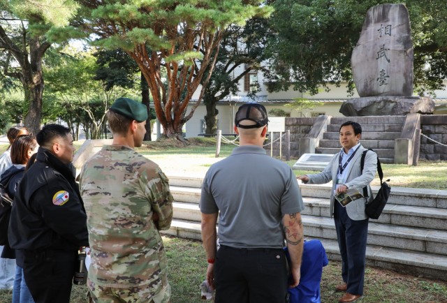 Kenji Toyomura, right, deputy chief of public engagement for the Public Affairs Office, provides a briefing on the Sobudai Monument near the main gate during the &#34;Bring Your Kids to Work Day&#34; event at Camp Zama, Japan, Nov. 4, 2024. Dozens...