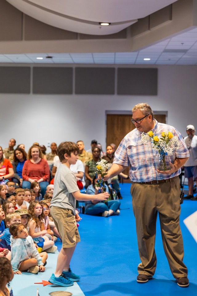 Mr. Amuso hands yellow roses to Ellis D. Parker Elementary students of deployed Soldiers during the annual Veterans Day Program Nov. 7, 2024.