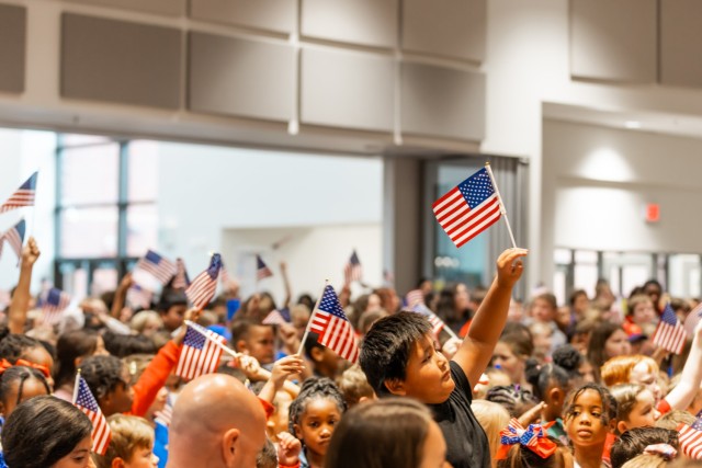 Ellis D. Parker Elementary School students raise their flags while singing “God Bless the USA” during the annual Veterans Day Program Nov. 7, 2024.
