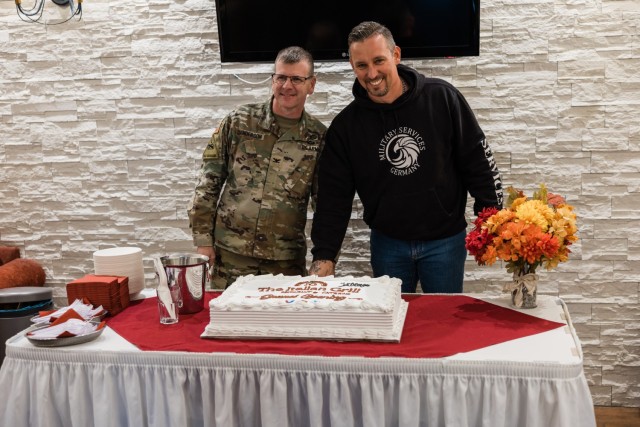 USAG Wiesbaden Commander Col. Troy Danderson and Christian Kaesemann, owner of The Italian Grill, cut the cake during the restaurant&#39;s official grand opening at The Airlift on Clay Kaserne Nov. 7, 2024. (Wiesbaden FMWR Photo by Travis Thurston)