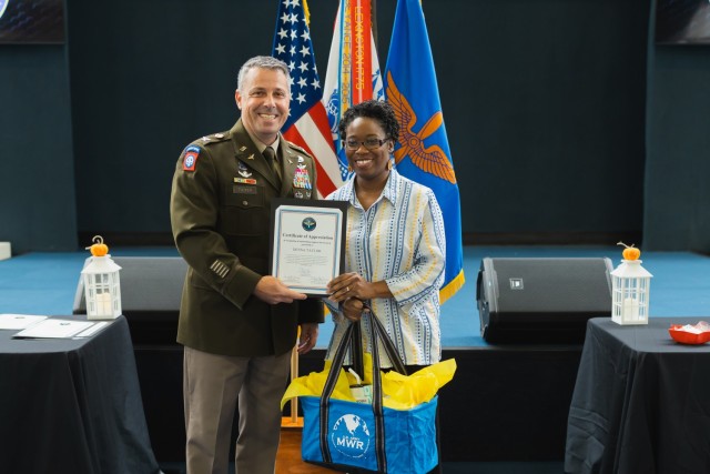 Col. Richard P. Tucker, USAACE chief of staff, presents Deanna Taylor, religious support office volunteer, with volunteer of the quarter at the Army Aviation Museum Nov. 12.