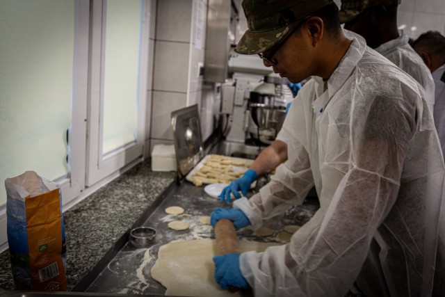 Pvt. 1st Class Angel Sanchez of the 7th Squadron, 17th Cavalry Regiment, learns how to make traditional Polish pierogis alongside Polish culinary professionals during a Polish and American forces cross-training workshop at Boleslawiec, Poland, on Nov. 5, 2024. The workshop brought together Polish and U.S. Army culinary specialists to share holiday meal traditions, fostering camaraderie and cultural exchange through hands-on culinary collaboration. (U.S. Army Photo by Bryan Araujo)