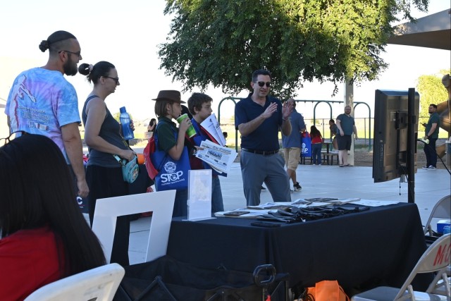 U.S. Army Yuma Proving Ground Public Affairs Officer Mark Schauer (right) narrates a dynamic video of the post&#39;s developmental test mission to attendees of the first annual Mesquite Elementary School Community Fair on November 13, 2024.