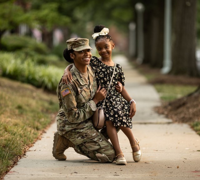 A Soldier poses with her daughter.