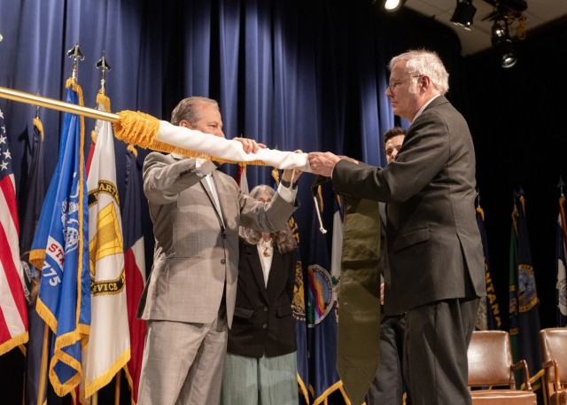 PICATINNY ARSENAL, N.J. - Chris Grassano, Director of the U.S. Army Combat Capabilities Development Command (DEVCOM) Armaments Center, (left) assists with casing the Senior Executive Service flag during the retirement ceremony of Brian E. Fuchs, a...