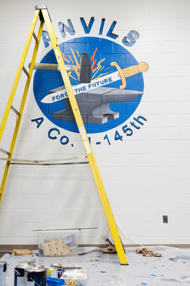 Carolyn Brown, Fort Novosel spouse and local artist, paints an updated mural of the A Co. 1-145th logo in an Aviation CCC classroom on Fort Novosel Nov. 20.