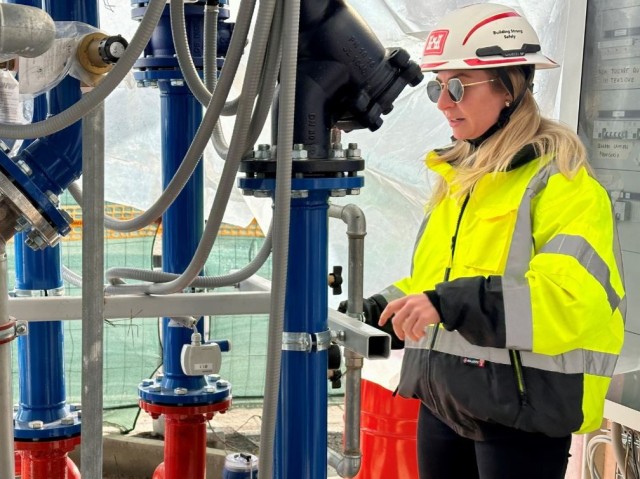 Callie Carmichael, a mechanical engineer with the USACE Mediterranean Resident Office, inspects a new  steam to high-temperature water exchanger at at Caserma Ederle., Vicenza.