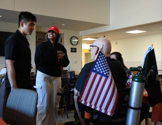 This is the second year Better Opportunities for Single Soldiers President Sgt. Jason Yang (left) takes part in the luncheon. He and Vice-President Pfc. Hardi Patel are pictured chatting with a resident.