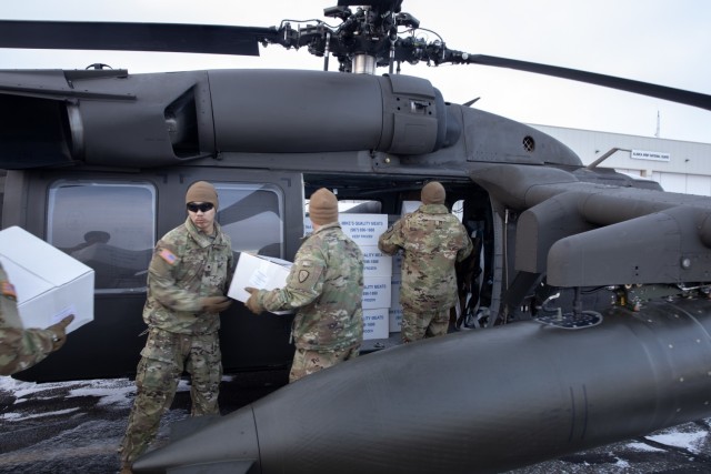 Alaska Army National Guardsmen from the 207th Aviation Troop Command and Bison Company, 1st Battalion, 297th Infantry Regiment, load frozen meat for transport via UH-60L Black Hawk helicopter during an Innovative Readiness Training mission at the AKARNG hangar in Bethel, Alaska, Nov. 18, 2024. Two years ago, the community of Toksook Bay, whose population is almost entirely members of the Alaska Native Nunakauyarmiut Tribe living a subsistence lifestyle, lost thousands of pounds of meat that spoiled due to extended power outages caused by Typhoon Merbok flooding. (Alaska National Guard photo by Seth LaCount)