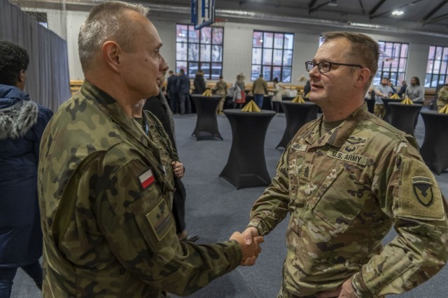 Command Sgt. Maj. Jason Jones, incoming senior enlisted advisor, speaks to Lt. Col. Slawomir Zawistowski, deputy commander of the 14th Garrison Support Unit, during the Garrison fall reception, Nov. 26, on Camp Kosciuzko, Poland. USAG Poland,...